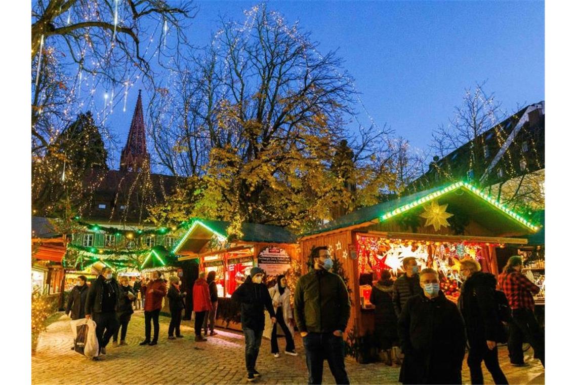 Menschen stehen vor Verkaufsständen auf dem Freiburger Weihnachtsmarkt. Foto: Philipp von Ditfurth/dpa/Bildarchiv