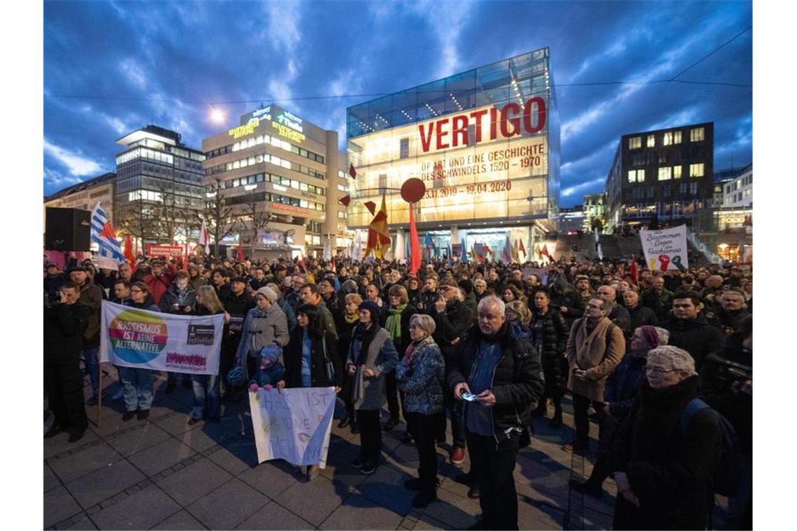 Menschen stehen während einer Gedenkveranstaltung für die Opfer von Hanau auf dem Schloßplatz. Foto: Sebastian Gollnow/dpa
