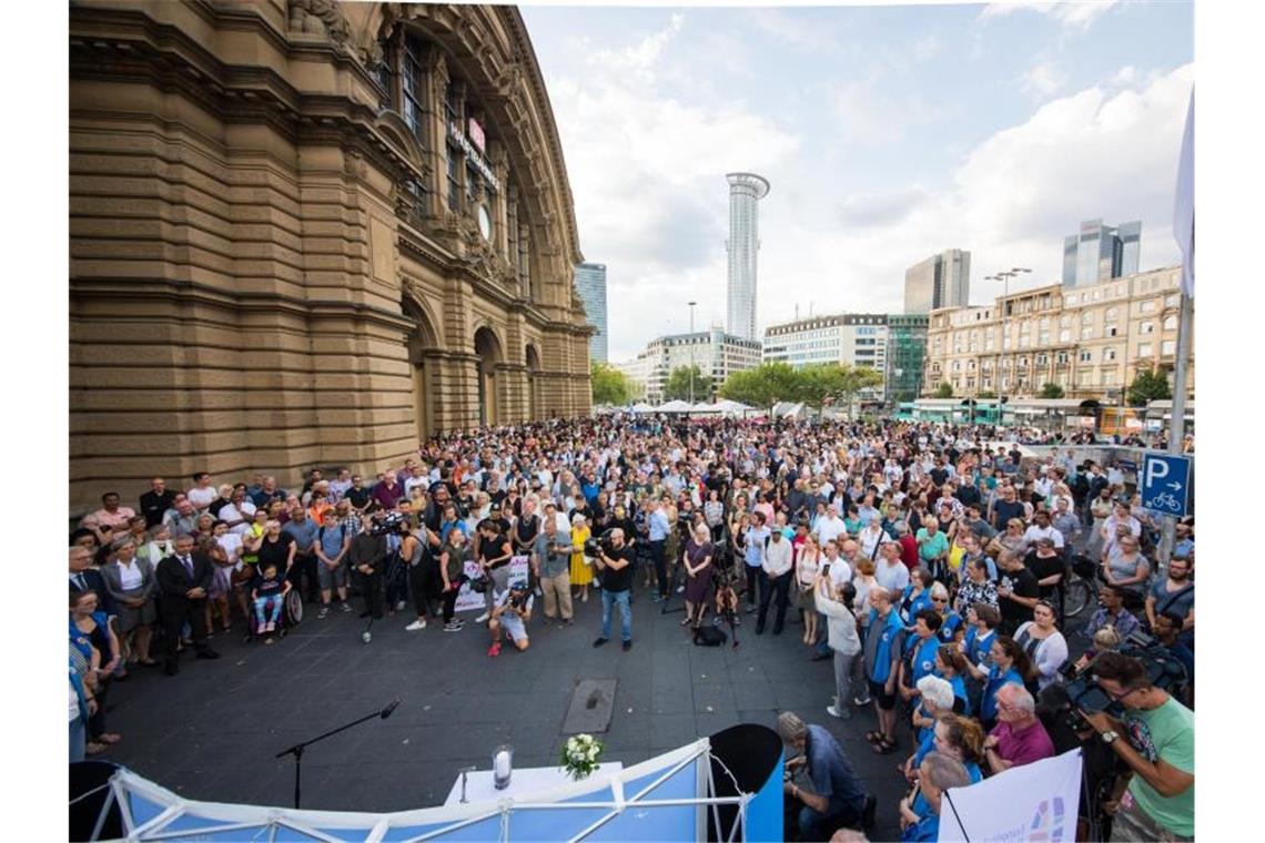 Menschen stehen während einer Trauerandacht vor dem Frankfurter Hauptbahnhof. Foto: Andreas Arnold