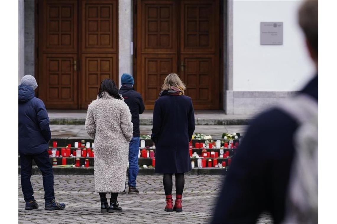 Heidelberg: Bewegende Trauerfeier für Amoklauf-Opfer Menschen stehen zur Gedenkminute vor dem Haupteingang der Neuen Universität. Foto: Uwe Anspach/dpa