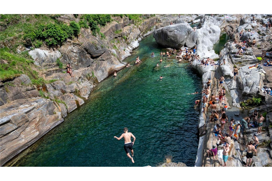Menschen suchen Abkühlung im Wasser des Flusses Verzasca in der Schweiz.