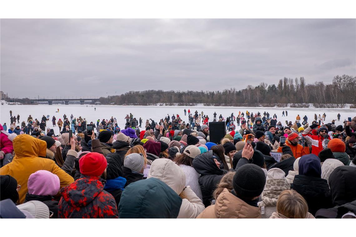 Menschen tanzen um einen DJ am Ufer des Flusses Dnipro in der Ukraine, um sich aufzuwärmen. Russlands Luftangriffe auf das Energiesystem machen, dass viele Ukrainer ohne Heizung sind.