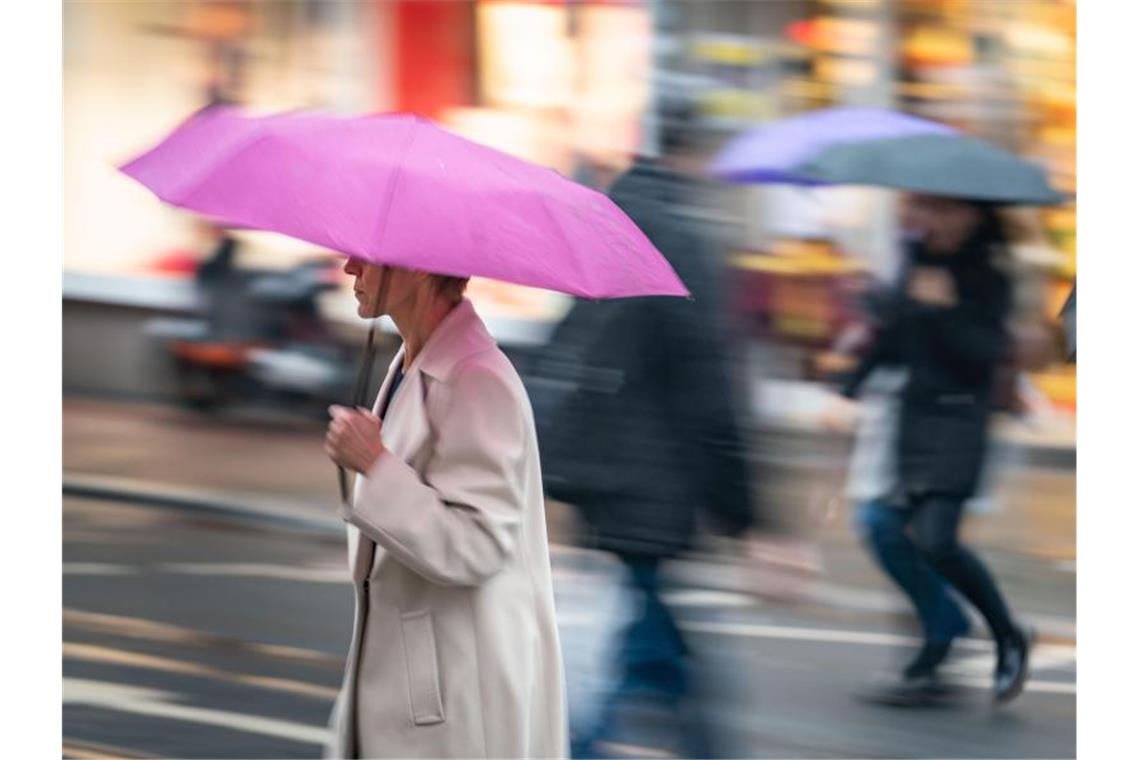 Menschen überqueren bei andauerndem Nieselregen eine Kreuzung. Foto: Frank Rumpenhorst/dpa/Archivbild