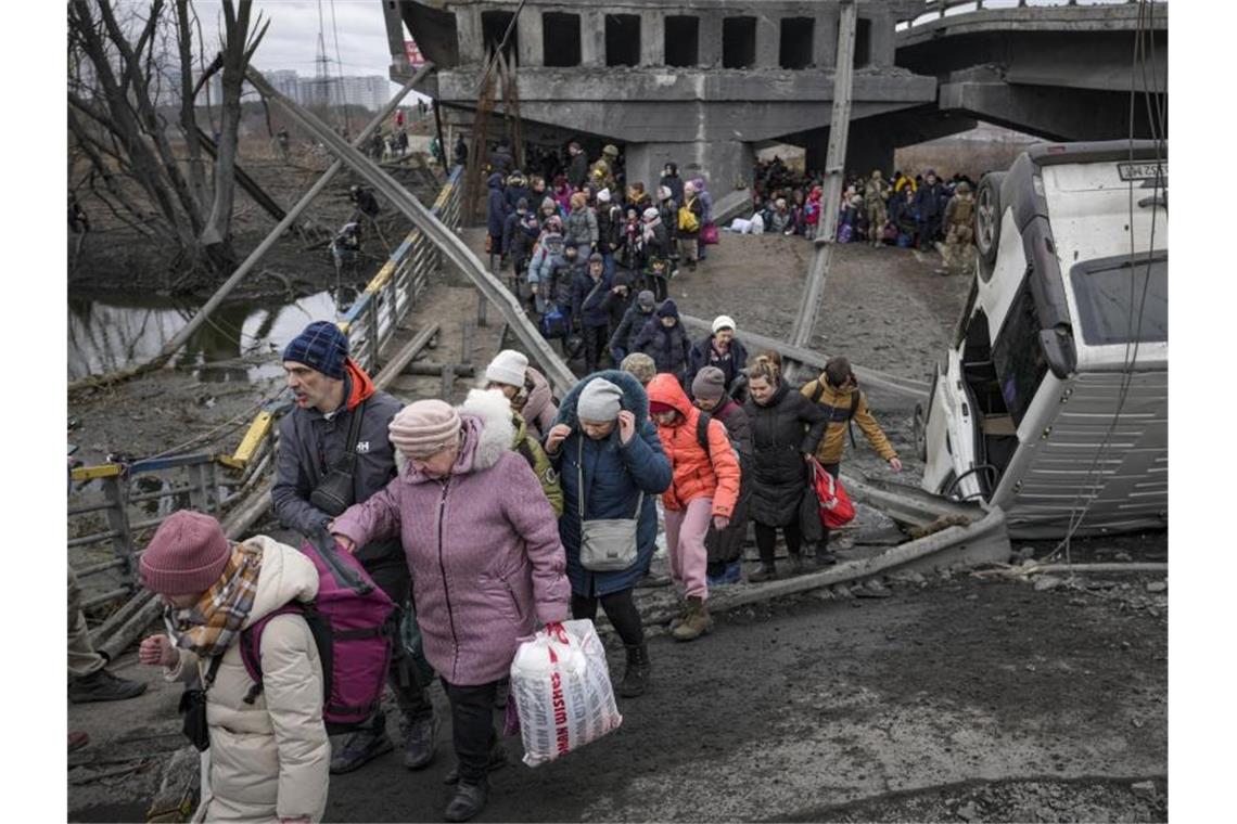 Russland setzt Angriff auf Mariupol fort Menschen überqueren den Fluss Irpin auf einem improvisierten Weg unter einer durch einen russischen Luftangriff zerstörten Brücke. Foto: Vadim Ghirda/AP/dpa