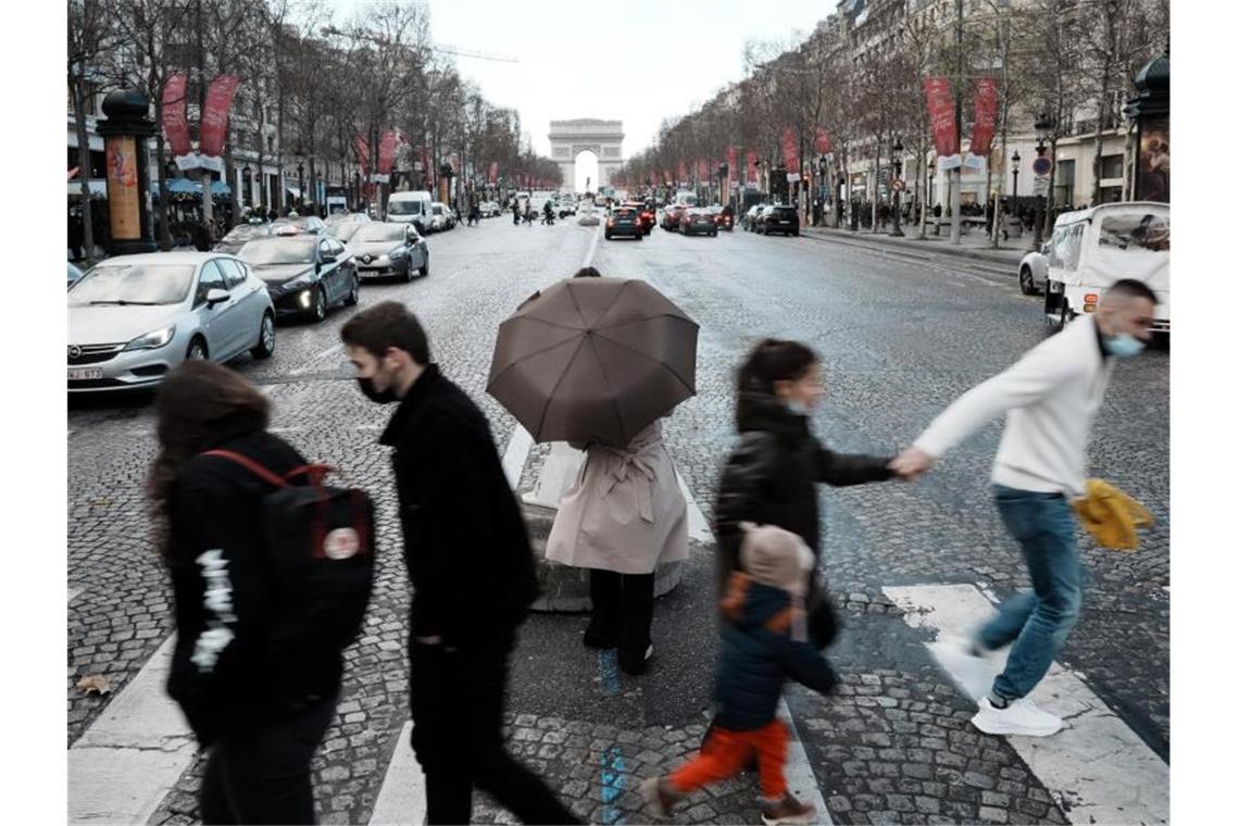 Rekordwert von rund 208.000 Neuinfektionen in Frankreich Menschen überqueren die Avenue des Champs-Élysées in Paris. In Frankreich wurden rund 208.000 Neuinfektionen gemeldet. Foto: Thibault Camus/AP/dpa