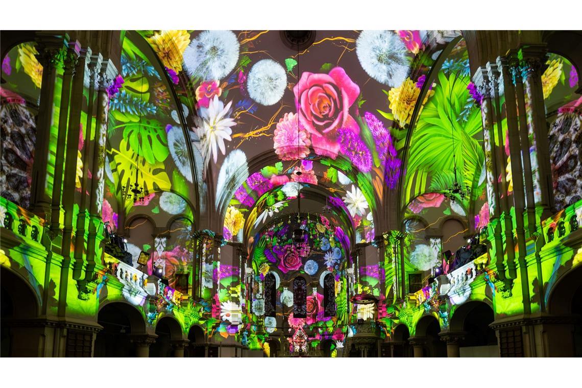 Menschen verfolgen in der Dresdner Martin-Luther-Kirche eine Lichtshow.