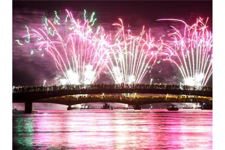 Menschen verfolgen von zwei über den Rhein führenden Brücken aus das Feuerwerk des Seenachtfestes. Foto: Felix Kästle/Archivbild