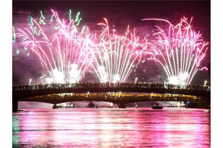 Menschen verfolgen von zwei über den Rhein führenden Brücken aus das Feuerwerk des Seenachtfestes. Foto: Felix Kästle/Archiv