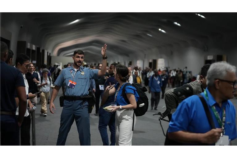 Menschen verlassen das Gelände der Weltklimakonferenz COP 30 wegen eines Feuers.