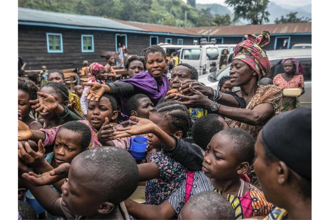 Hunderttausende auf der Flucht vor Vulkan Nyiragongo Menschen versammeln sich an einer Lebensmittelverteilungsstelle in Sake. Foto: Moses Sawasawa/AP/dpa