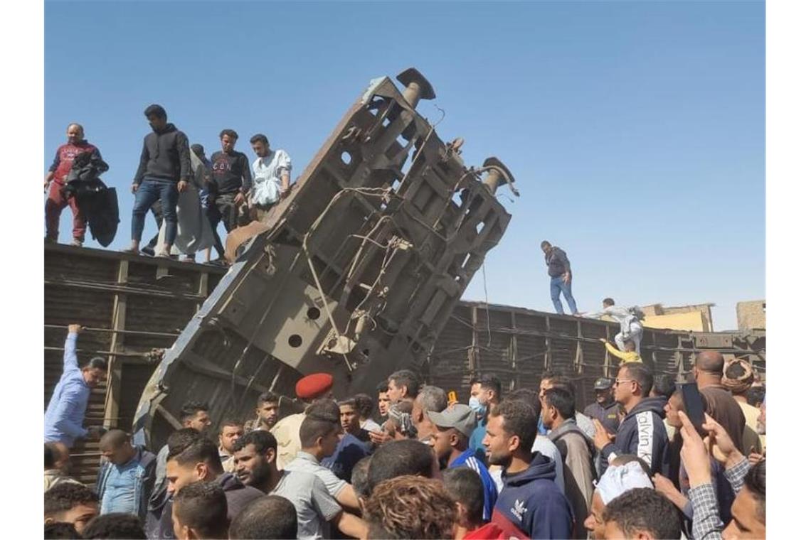 Mindestens 32 Tote bei Zusammenstoß zweier Züge in Ägypten Menschen versammeln sich nach dem Zusammenstoß der Züge an den beschädigten Waggons. Foto: Mahmoud Maqboul/dpa
