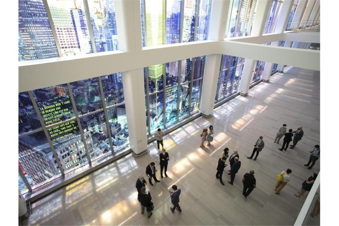 Terminal an New Yorker Flughafen öffnet: Mit deutscher Kunst Menschen versammeln sich neben bunten Fensterillustrationen. Foto: Mark Lennihan/AP/dpa