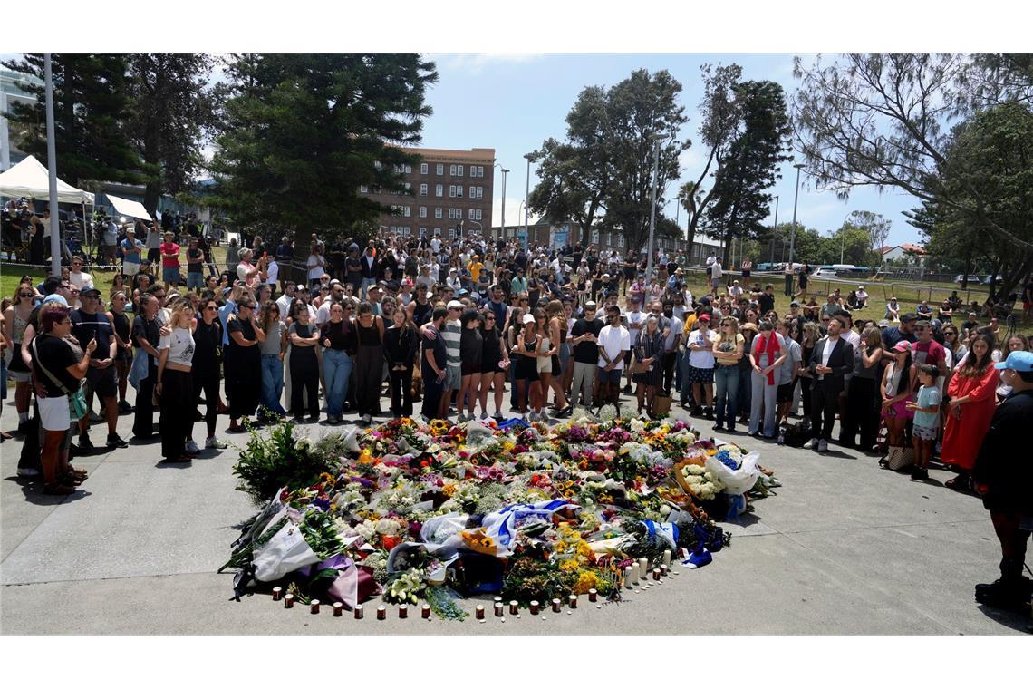 Menschen versammelt sich einen Tag nach einer Schießerei am Bondi Beach in Sydney um ein Blumendenkmal.