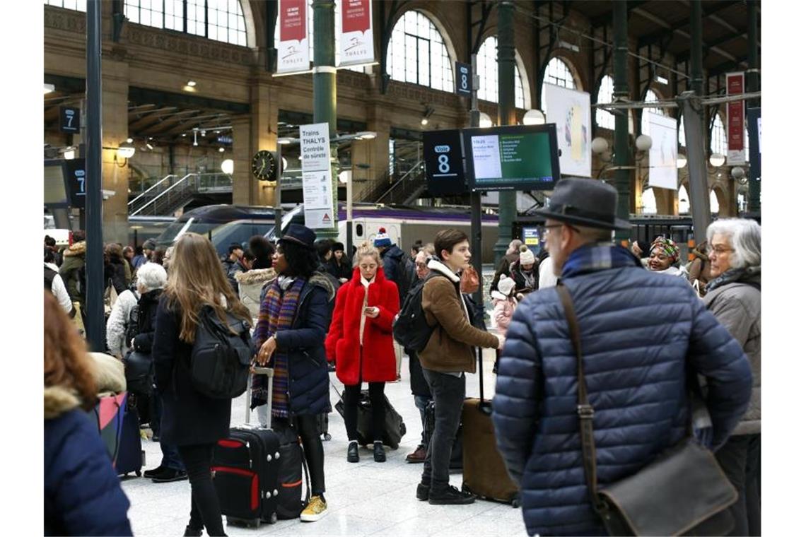 Menschen warten am Bahnhof Paris-Nord auf ihre Züge. Wegen der Streiks gegen die geplante Rentenreform ist der Bahnverkehr im ganzen Land erheblich gestört. Foto: Thibault Camus/AP/dpa