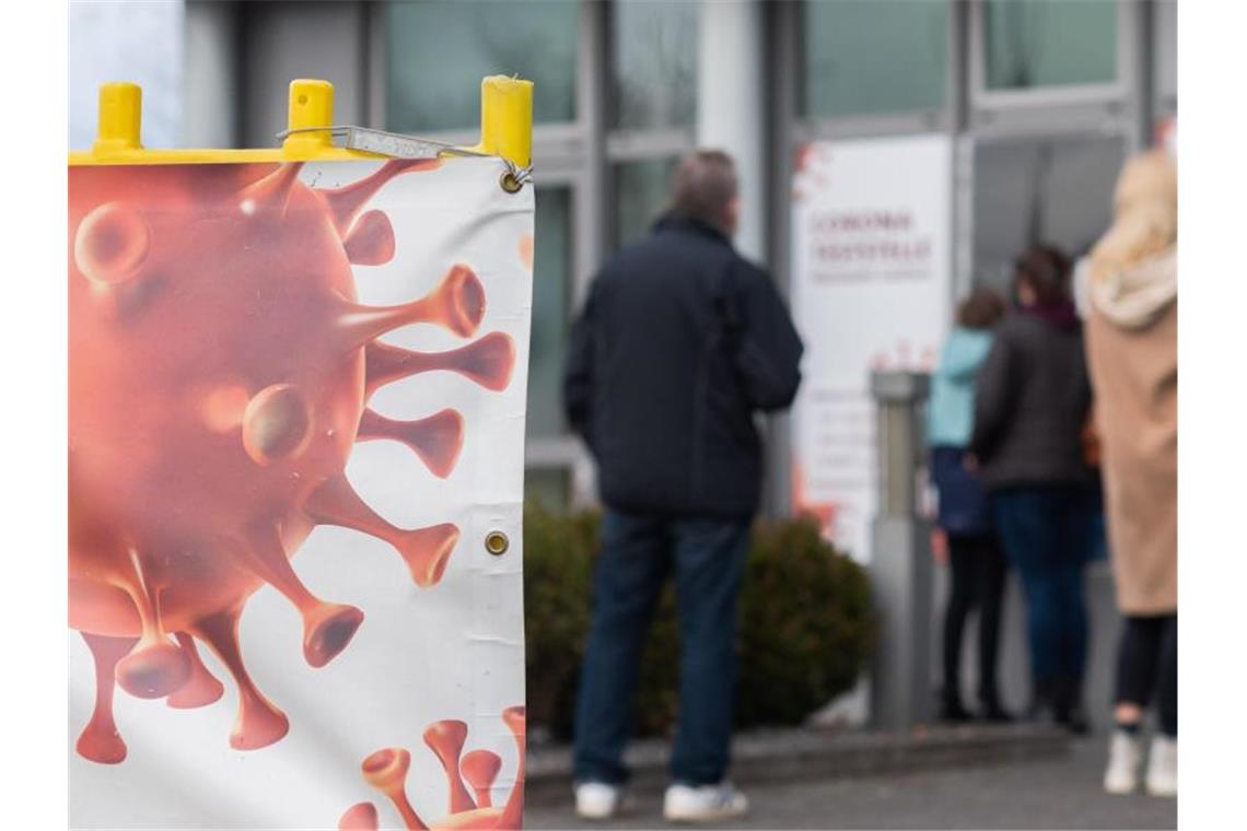 Menschen warten auf einen Coronatest an der von einer Arztpraxis betriebenen Corona-Teststelle. Foto: Julian Stratenschulte/dpa