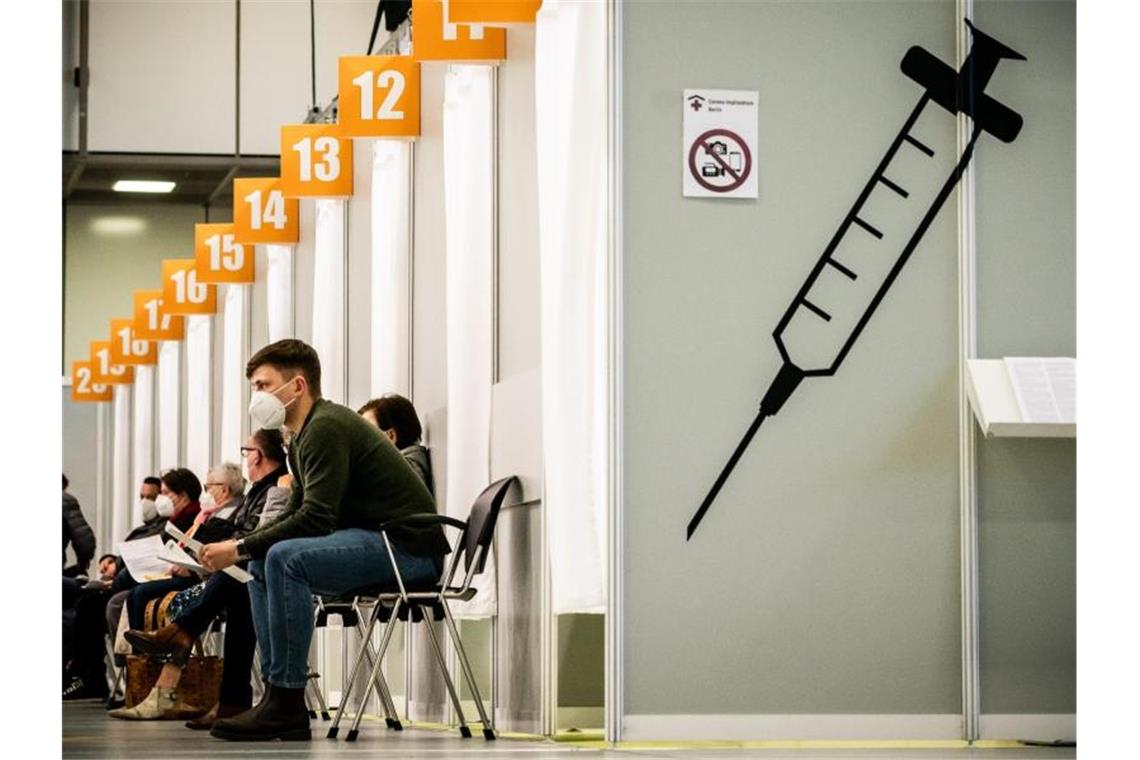 Diskussion über Strafen für Impfschwänzer Menschen warten im Corona-Impfzentrum auf dem Berliner Messegelände auf ihre Impfung. Mehrere Politiker fordern eine Strafe für Impfterminschwänzer. Foto: Michael Kappeler/dpa