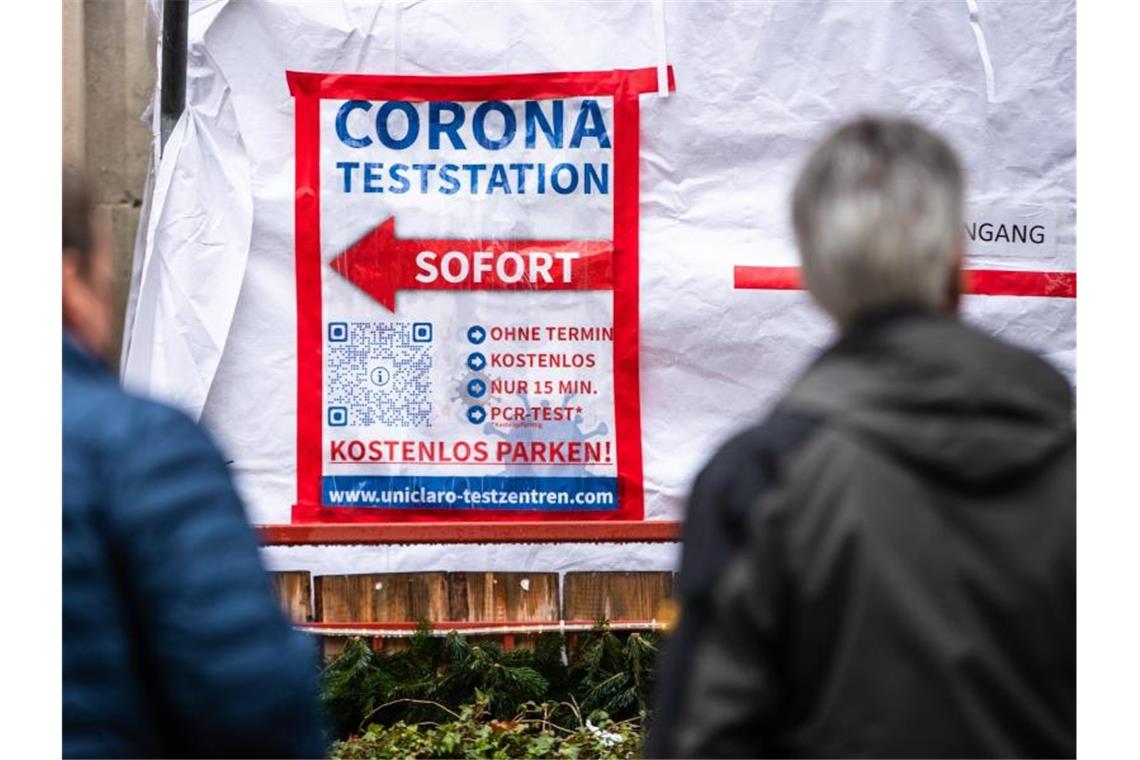 Menschen warten in der Stuttgarter Innenstadt vor einem Testzentrum. Foto: Christoph Schmidt/dpa