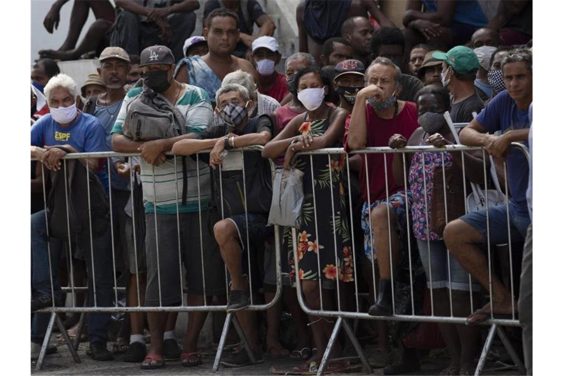 Corona beschleunigt Rückkehr des Hungers in Brasilien Menschen warten in Rio de Janeiro in einer Schlange auf eine kostenlose Mahlzeit. Foto: Silvia Izquierdo/AP/dpa