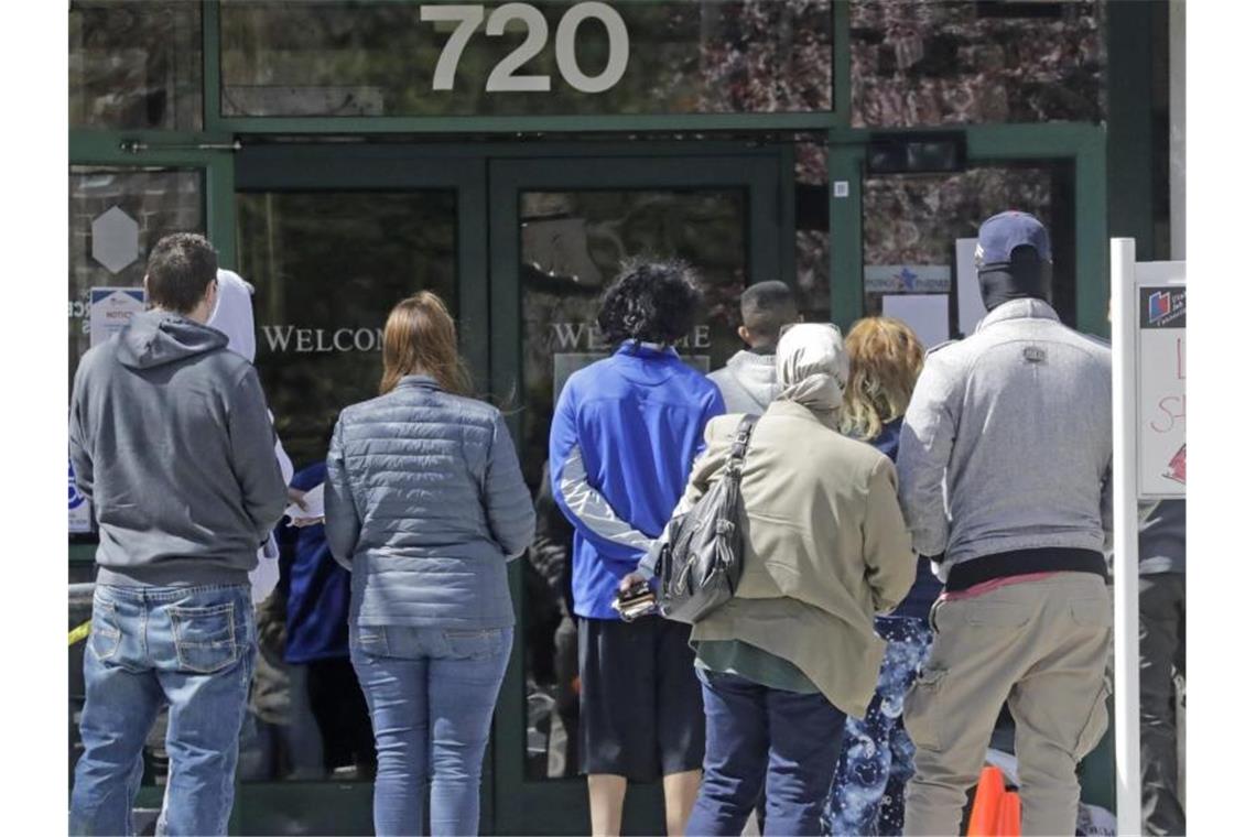 Menschen warten in Salt Lake City vor einem Arbeitsamt. Foto: Rick Bowmer/AP/dpa