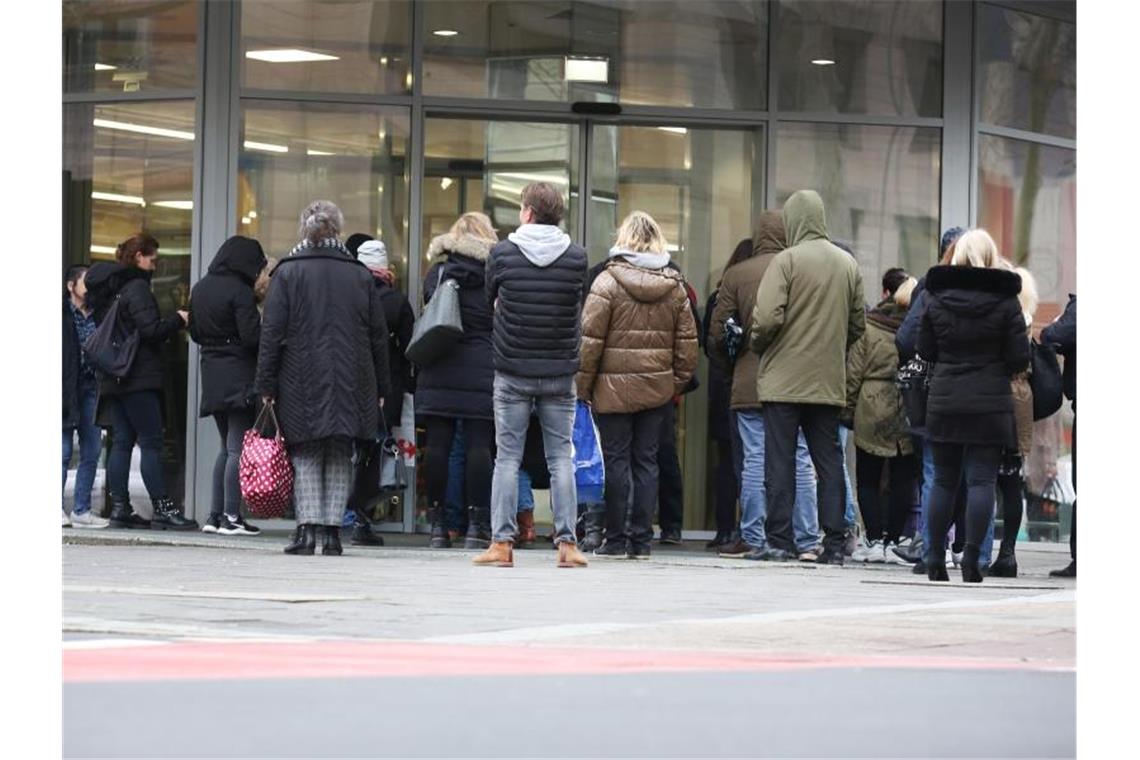 Menschen warten vor der Öffnung einer Aldi-Filiale vor dem Eingang.. Foto: Martin Gerten/dpa