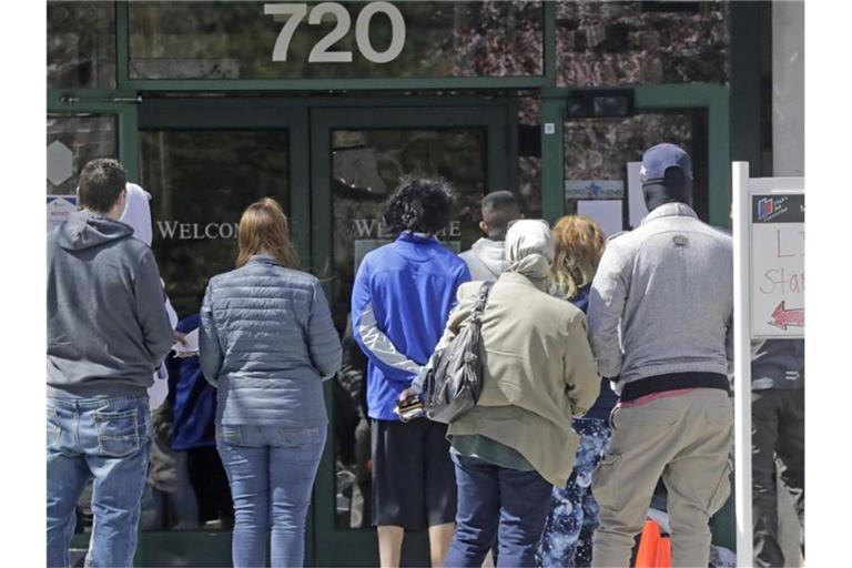 Menschen warten vor einem Arbeitsamt in Salt Lake City. Foto: Rick Bowmer/AP/dpa