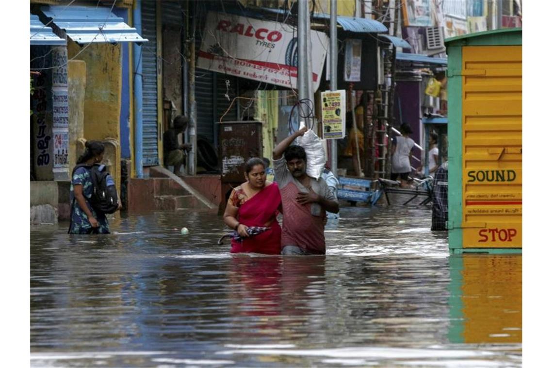 Zehntausende in Indien wegen Wirbelsturms in Notunterkünften Menschen waten durch eine überflutete Straße in Chennai. Sturm „Nivar“ soll viel Regen bringen und Windgeschwindigkeiten bis 130 km/h erreichen. Foto: R. Parthibhan/AP/dpa