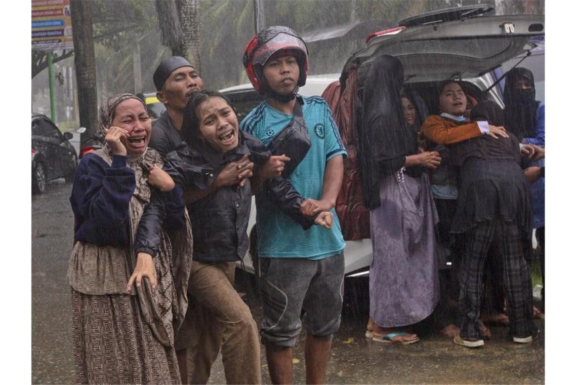 Dutzende Tote bei Erdbeben auf Sulawesi in Indonesien Menschen weinen, als Opfer aus den Trümmern eines Gebäudes geborgen werden, das in Folge eines Erdbeben eingestürzt ist. Foto: Yusuf Wahil/AP/dpa