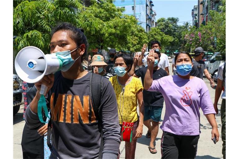 Menschen zeigen bei einer Demonstration in Yangon den Drei-Finger-Gruß als Zeichen des Widerstands. Foto: --/AP/dpa