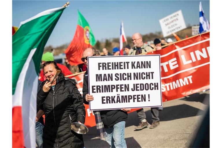 Menschen ziehen bei einer Demonstration gegen die Corona-Maßnahmen durch die Innenstadt. Foto: Christoph Schmidt/dpa