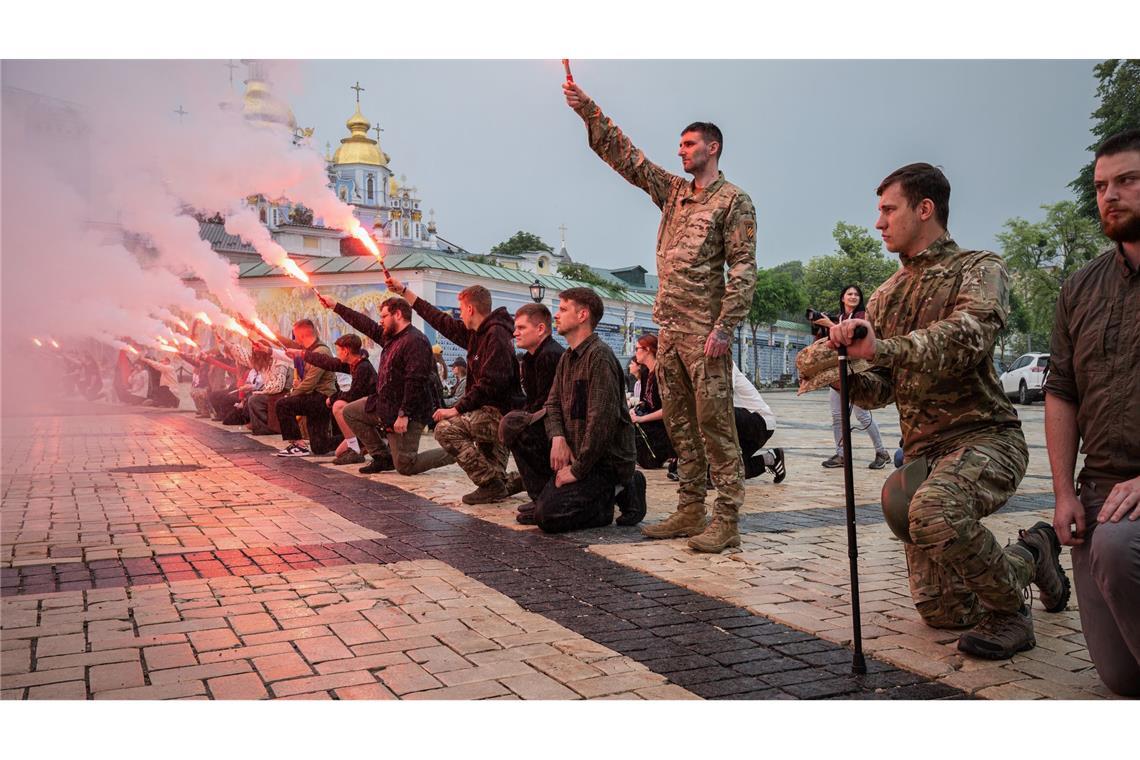 Menschen zünden Fackeln während der Beerdigungszeremonie für einen gefallenen ukrainischen Soldaten in Kiew.