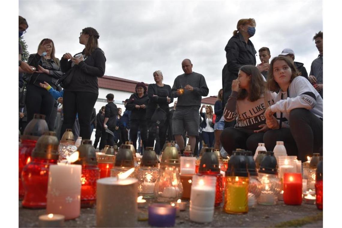 Menschen zünden Kerzen vor der Schule im Ort Vrutky an. Foto: Miroslava Mlyn·rov·/TASR/dpa