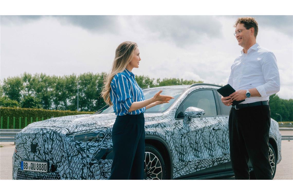 Der Mercedes-Chef testet den Anhänger und lädt Gemüse ein Mercedes-Chef Ola Källenius mit der Moderatorin Sarah Harman und einem noch getarnten elektrischen GLC.