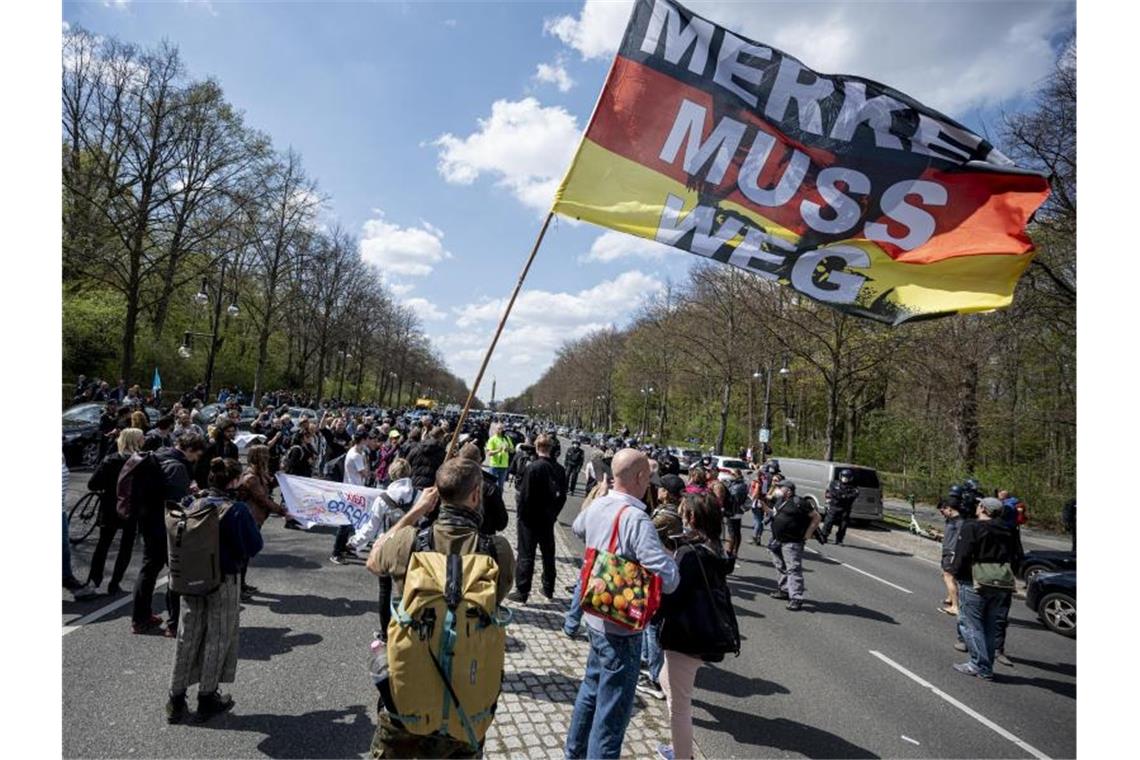 „Merkel muss weg“ steht auf der Flagge eines Demonstranten beim Protest gegen die Änderung des Infektionsschutzgesetzes in Berlin am 21. April (Symbol). Foto: Fabian Sommer/dpa