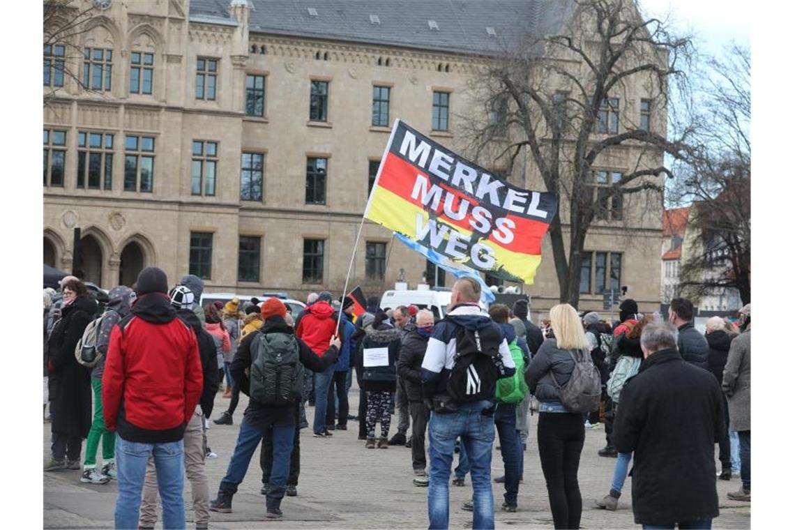 Tausende Teilnehmer bei Protesten gegen Corona-Maßnahmen „Merkel muss weg“ steht bei der Demonstration von Gegnern der Corona-Politik in Erfurt auf einer Flagge. Foto: Bodo Schackow/dpa-Zentralbild/dpa