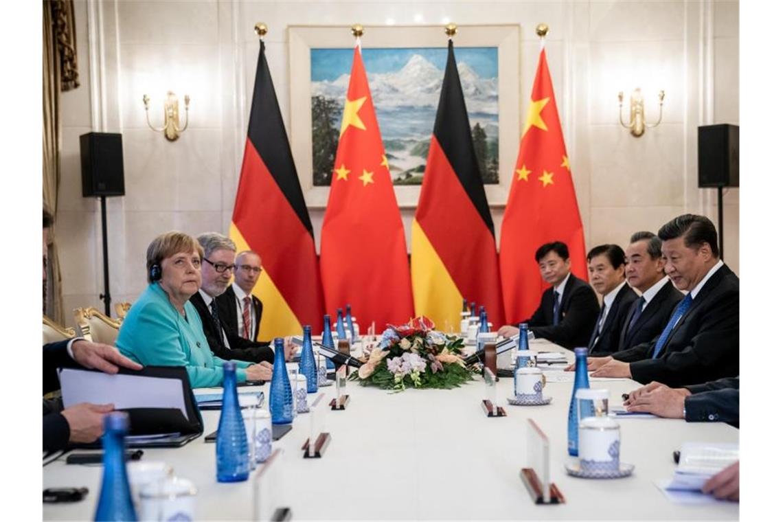 Merkel sitzt Xi bei einem Gespräch im erweiterten Kreis gegenüber. Foto: Michael Kappeler