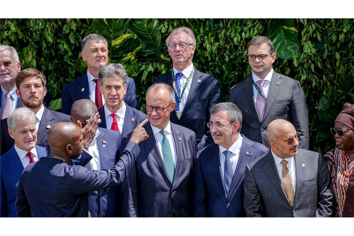 Merz stellt sich zum Familienfoto auf der COP30 auf.