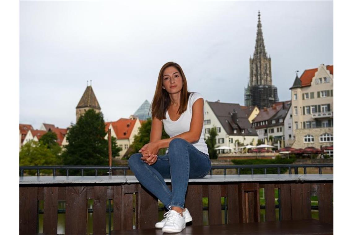 Mesale Tolu sitzt auf einem Geländer vor der Ulmer Altstadt. Foto: Stefan Puchner
