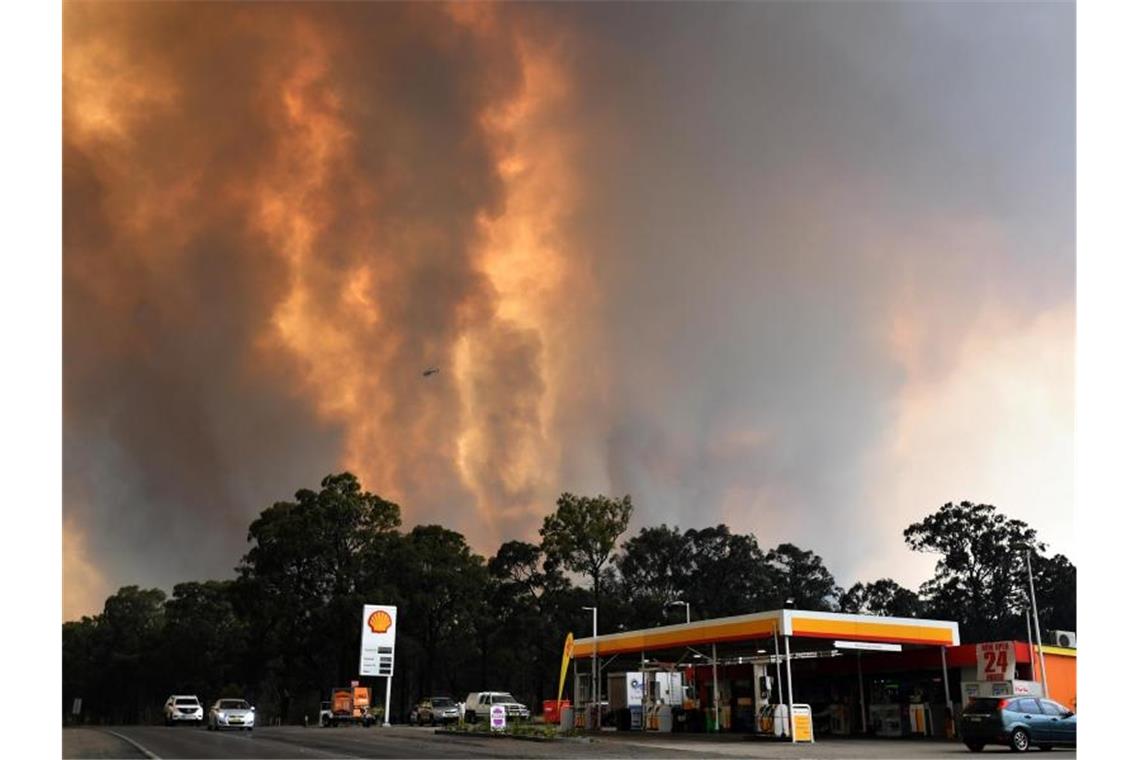 Meterhohe Flammen steigen südwestlich von Sydney in der Nähe einer Tankstelle auf. Foto: Dean Lewins/AAP/dpa