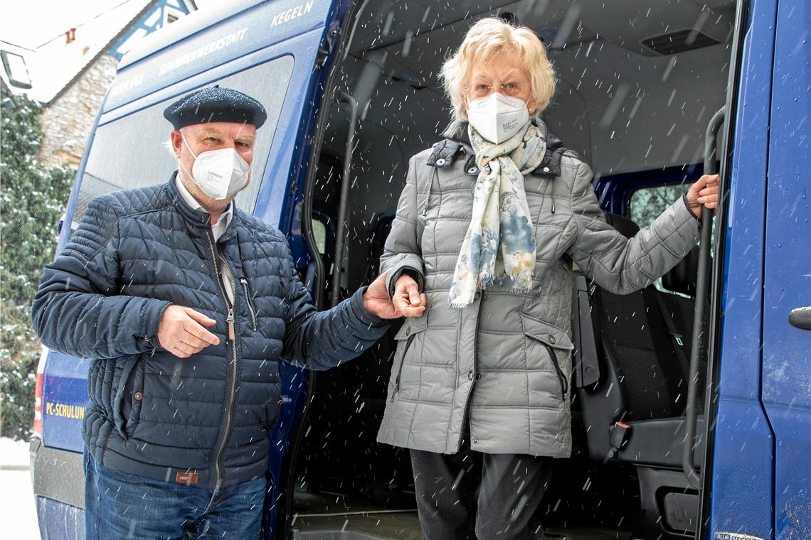 Michael Balzer vom Seniorenbüro hilft Marianne Karp nach ihrem Impftermin im Robert-Bosch-Krankenhaus in Stuttgart beim Aussteigen aus dem Seniorenmobil. Foto: A. Becher 