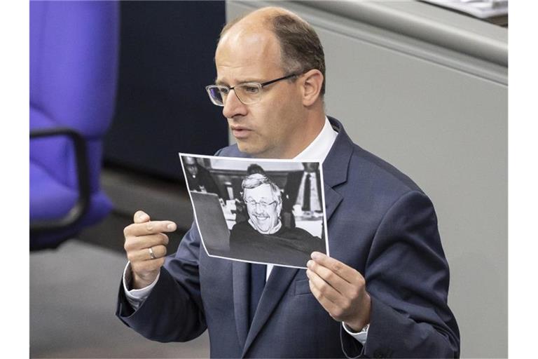 Michael Brand (CDU) hält bei seiner Rede im Bundestag ein Bild des ermordeten Kasseler Regierungspräsidenten Walter Lübcke. Foto: Christoph Soeder