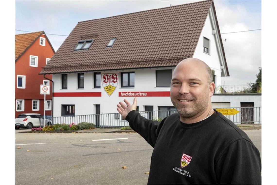 Michael Neuweiler steht vor seinem Haus, das in den Farben rot-weiß und dem Vereinswappen des VfB Stuttgart angestrichen ist. Foto: Uli Deck/dpa