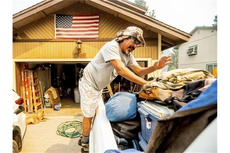 Michael Posadas bereitet sich nahe des Lake Tahoe auf die Evakuierung vor. Das beliebte kalifornische Ausflugsgebiet ist von schnell um sich greifenden Waldbränden bedroht. Foto: Noah Berger/AP/dpa