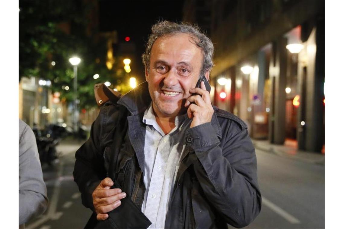 Michel Platini telefoniert nach seiner Entlassung aus dem Gewahrsam der Polizei. Foto: Francois Mori/AP