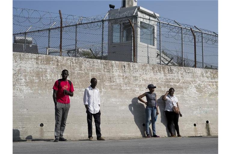 Migranten an einer Mauer des Flüchtlingslagers Moria auf der Insel Lesbos. Foto: Petros Giannakouris/AP/dpa