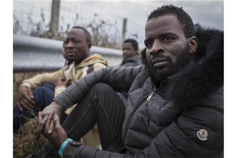 Migranten aus Togo harren auf der Straße aus, nachdem sie, aus der Türkei kommend, den Grenzfluss Evros durchquert hatten und von griechischen Soldaten festgenommen worden waren. Foto: Socrates Baltagiannis/dpa