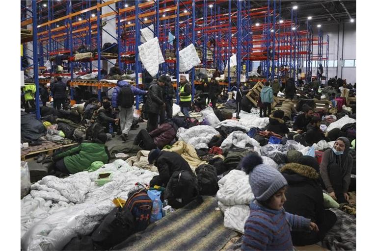 Migranten, die sich für die Nacht im Logistikzentrum am Kontrollpunkt „Kuznica“ an der belarussisch-polnischen Grenze einrichten. Foto: Maxim Guchek/BelTA/AP/dpa
