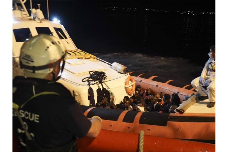 Migranten sitzen in einem Boot der italienischen Küstenwache, nachdem sie von Bord des Rettungsschiffs „Ocean Viking“ gegangen sind. Foto: Renata Brito/AP