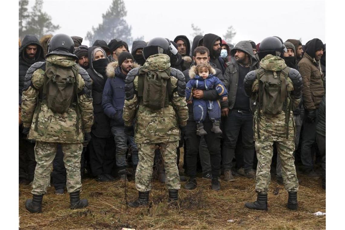 Polens Grenzschutz: Belarus bereitet Sturm der Grenze vor Migranten stehen an der belarussisch-polnischen Grenze vor belarussischen Soldaten. Foto: Oksana Manchuk/BelTA-Pool/AP/dpa