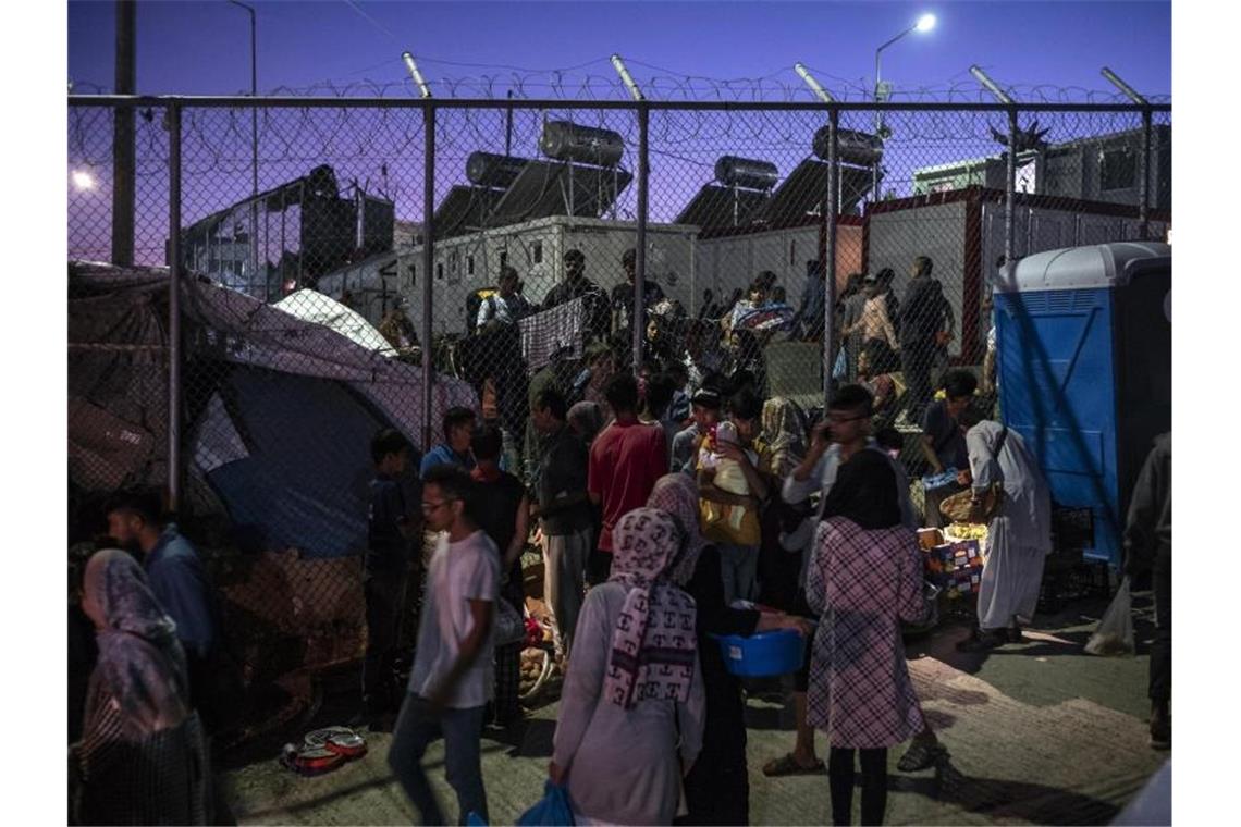 Flüchtlinge im Mittelmeer: Griechenland wieder im Fokus Migranten verlassen das Lager Moria aus Lesbos durch ein Loch im Zaun. Foto: Angelos Tzortzinis/dpa