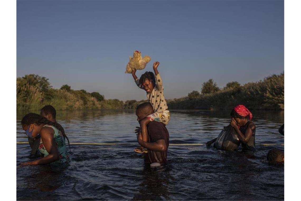 Einsatz gegen Migranten - Kritik an US-Beamten auf Pferden Migranten, viele von ihnen aus Haiti, überqueren den Rio Grande in Del Rio, Texas. Foto: Felix Marquez/AP/dpa